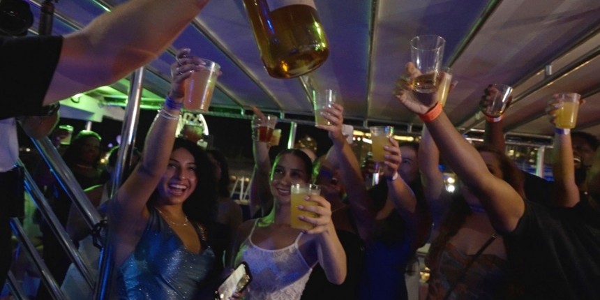 Group of friends dancing and celebrating on our luxury party yacht with Miami skyline in the background